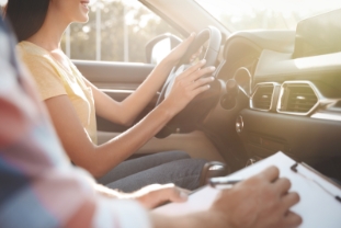 Young woman in car with instructor